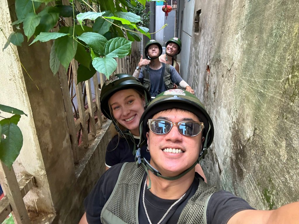 Visitors discovering hidden alleys and local life on a Hanoi Backstreet Motorbike Tour.