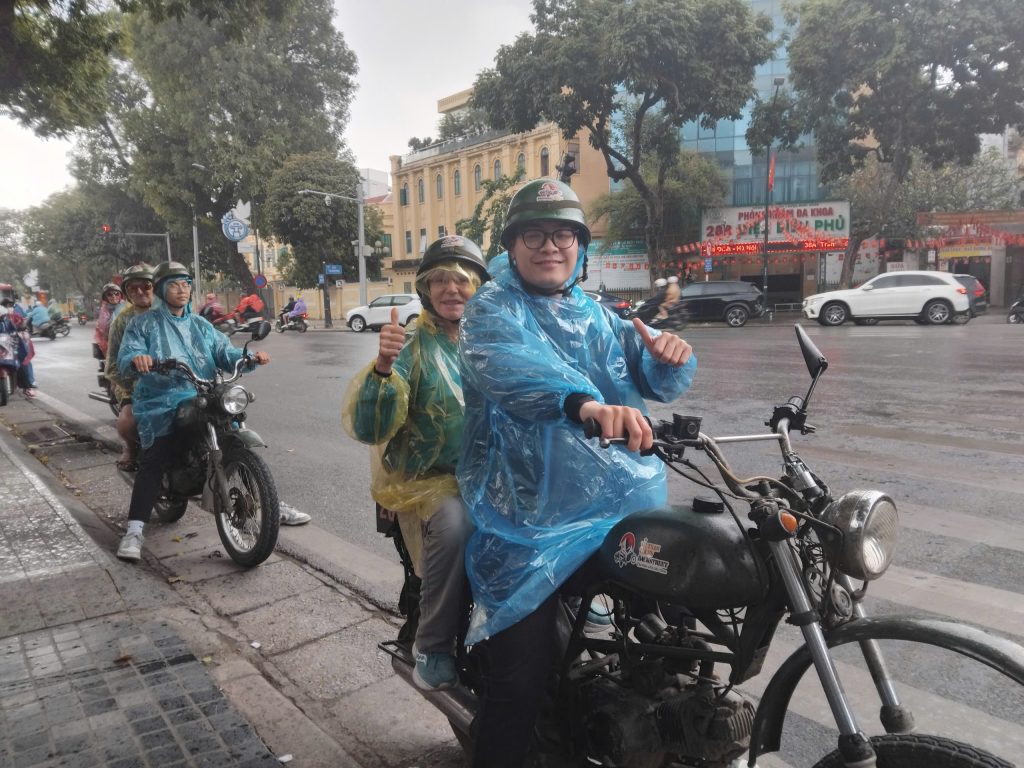 Guests enjoying a Hanoi Motorbike Tour safely even during rainy weather.