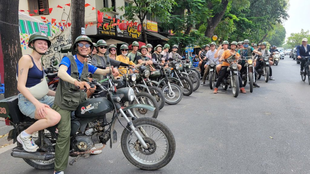 "Large group enjoying a Hanoi Motorbike Tour with local guides"